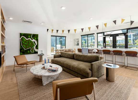 A living room with a green painting on the wall and a large sectional sofa.