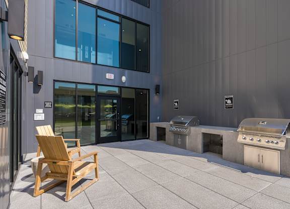A wooden chair is placed on a patio in front of a building.