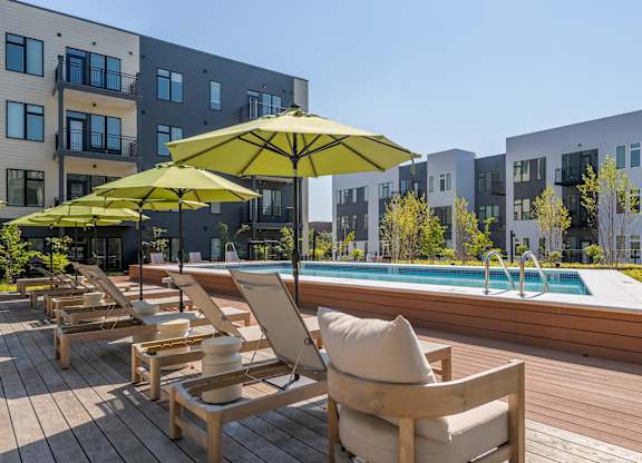 A poolside area with chairs and umbrellas.