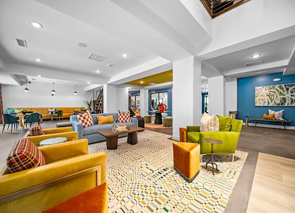 A spacious living room with a patterned rug and a variety of seating options.