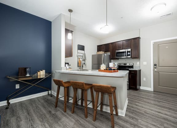 a kitchen with a large island with three stools
