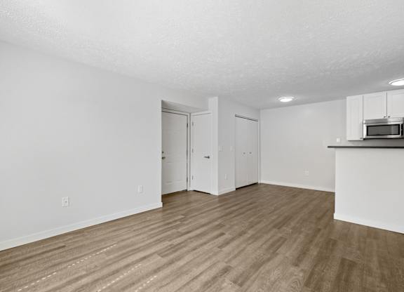 A room with wooden flooring and white walls.