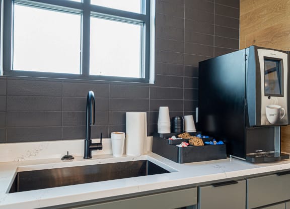 a kitchen with a sink and a coffee maker