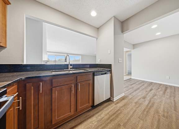A kitchen with wooden cabinets and a black countertop.