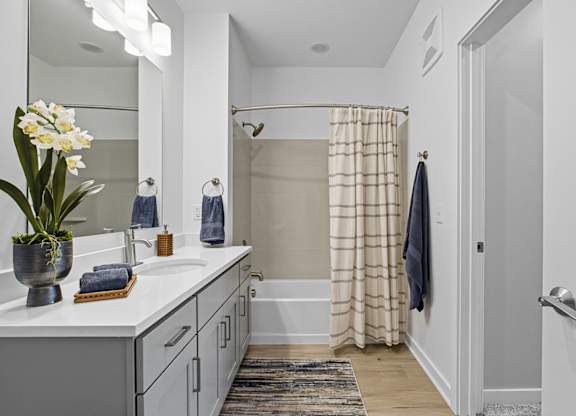 A bathroom with a white sink and a mirror above it.