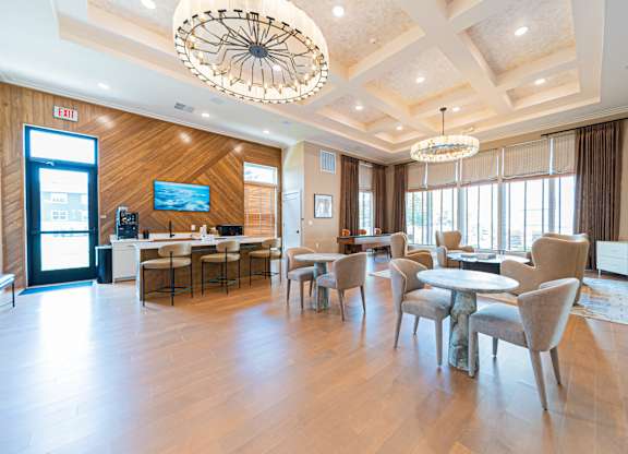 A large, well-lit room with a wooden floor and a chandelier hanging from the ceiling.