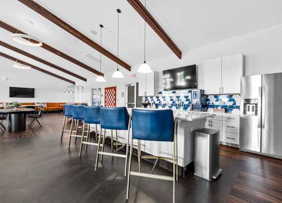 A kitchen with blue chairs and a white counter.