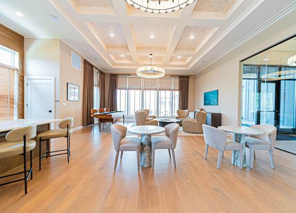 A large, well-lit dining room with a wooden floor and a chandelier.