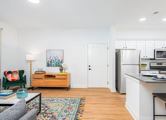 A kitchen with a refrigerator, microwave, and oven.