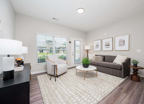 A living room with a grey couch, a white chair, and a coffee table.