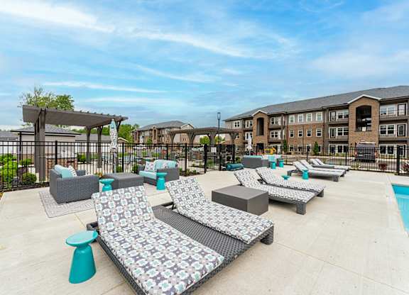 A patio area with grey couches and a pool.