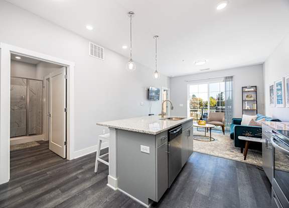 a kitchen with an island and a living room with a sliding glass door