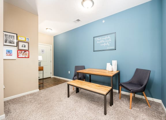 a home office with a blue wall and a desk with a chair and a table