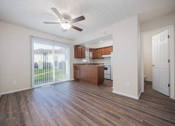 A room with a ceiling fan and wooden flooring.
