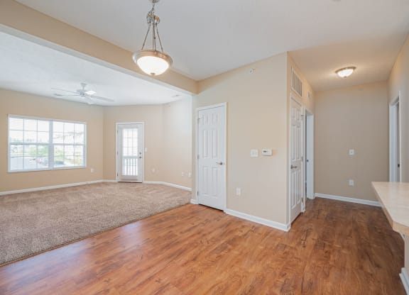 an empty living room and dining room with hard wood flooring