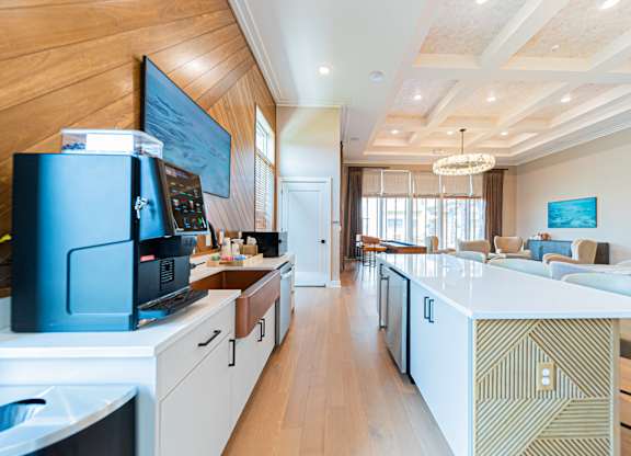 A modern kitchen with a white countertop and wooden cabinets.