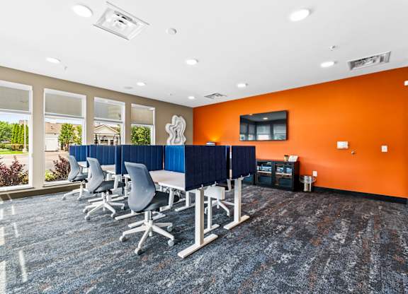 A conference room with orange walls and a long table with chairs.