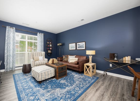 a living room with blue walls and a brown couch and chair