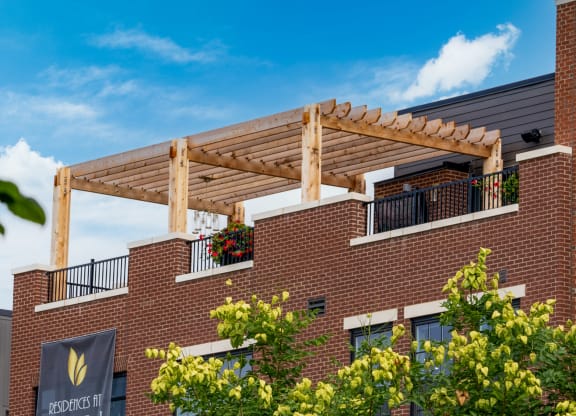a wooden pergola on top of a brick building