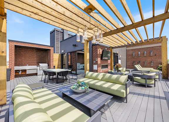 A wooden deck with a striped couch and a table.
