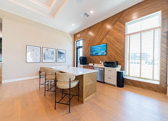 A modern kitchen with a wooden wall and a TV mounted above the island.