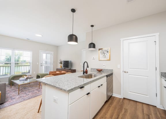 a kitchen with a counter top and a door to a living room