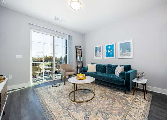 a living room with a blue couch and a window