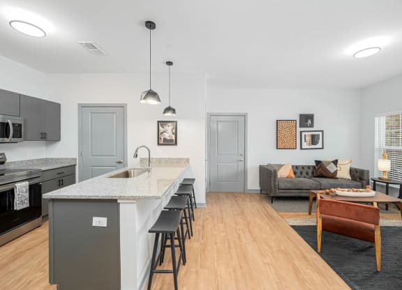 a kitchen with a long island and a living room with a couch
