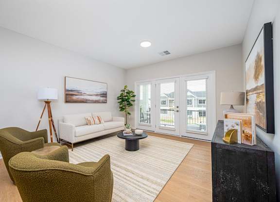 A living room with a white couch, a green armchair, and a coffee table.