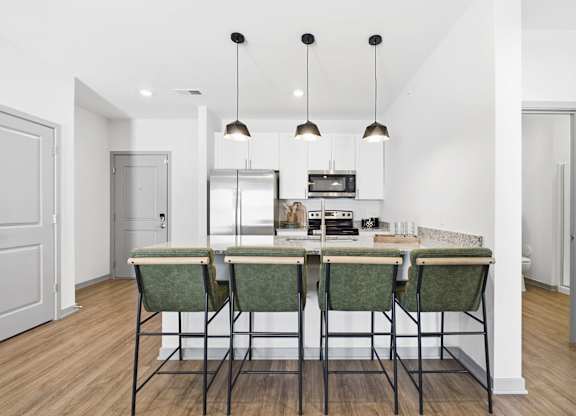 A kitchen with a table and chairs in the middle.