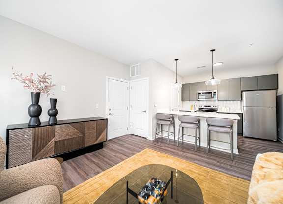 A modern kitchen with a dining area and a living room.