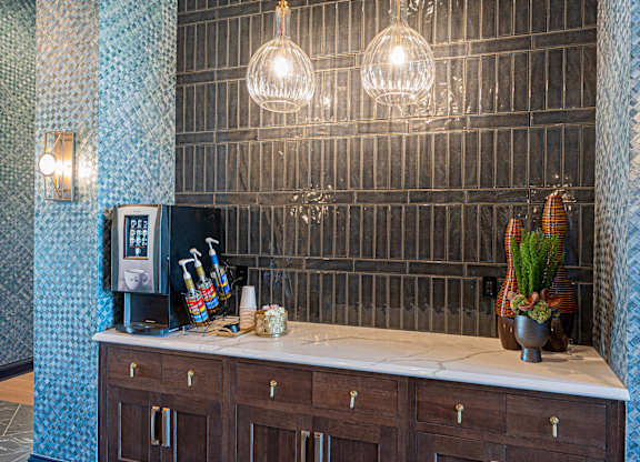 A kitchen counter with a coffee machine and a vase of flowers.
