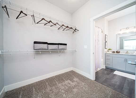 a white dressing room with a mirror and a bench