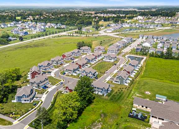 A bird's eye view of a residential area with houses and green lawns.