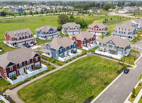 A suburban neighborhood with houses and cars parked on the street.