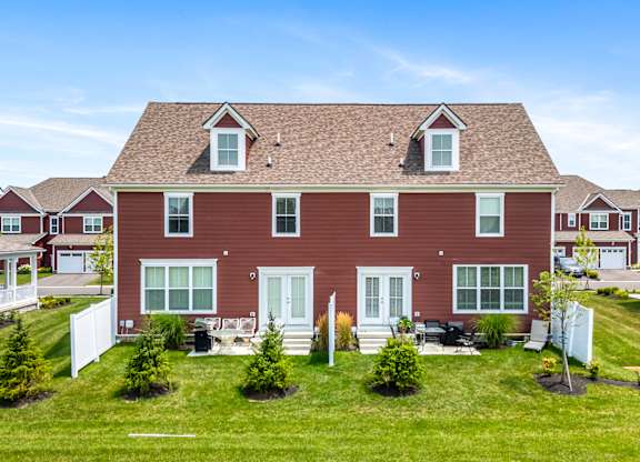 A red house with a white fence in front of it.