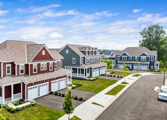 A row of houses with a car parked in front of the last one.