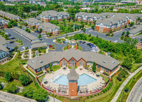 an aerial view of a building with a pool in a parking lot