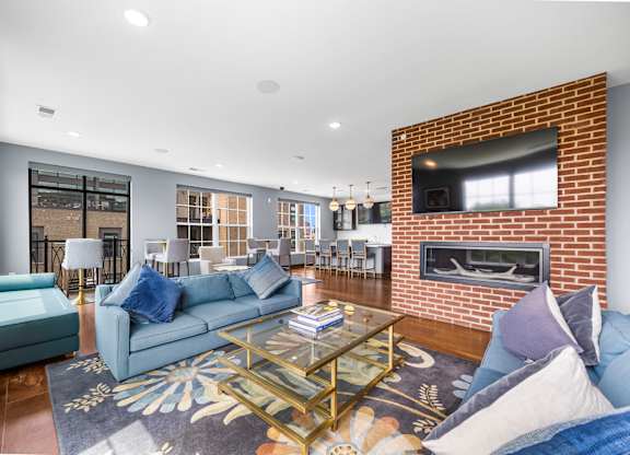A living room with a blue couch and a fireplace.