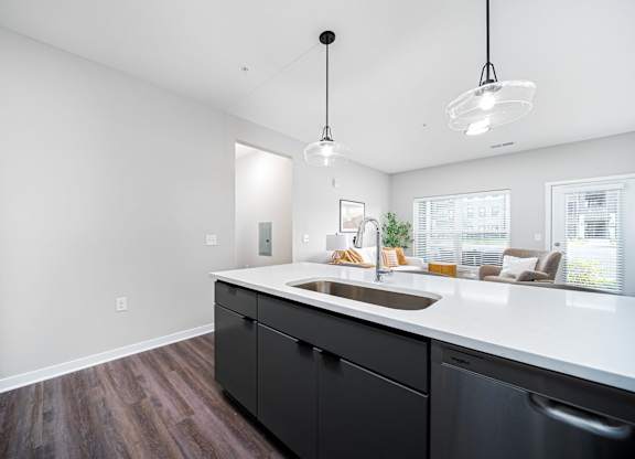 A kitchen with black cabinets and a white countertop.