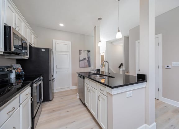 a kitchen with black counter tops and white cabinets