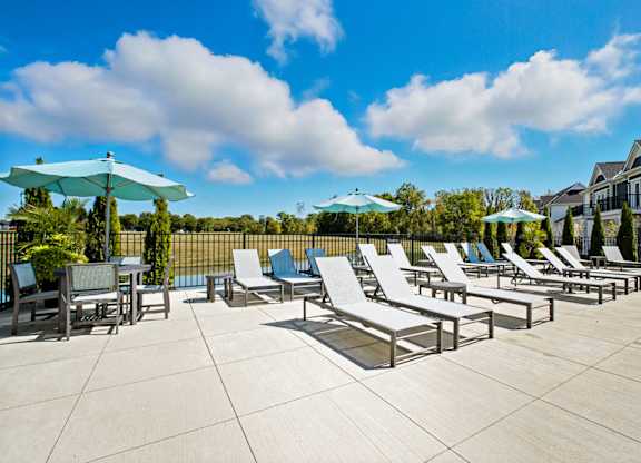 A sunny day at the outdoor pool area with lounge chairs and umbrellas.