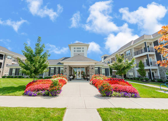 a building with a sidewalk and colorful flowers in front of it