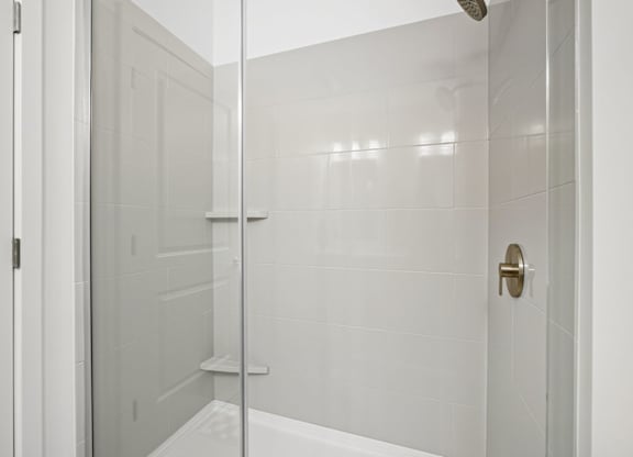 A white bathroom with a glass shower door.