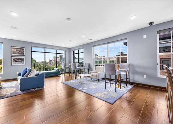 A living room with a blue couch and a rug.