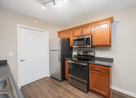 a kitchen with black appliances and wooden cabinets and a refrigerator