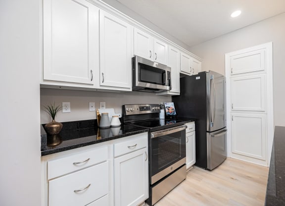 a kitchen with white cabinets and stainless steel appliances