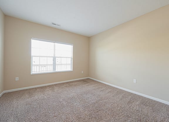 an empty room with carpet and a window