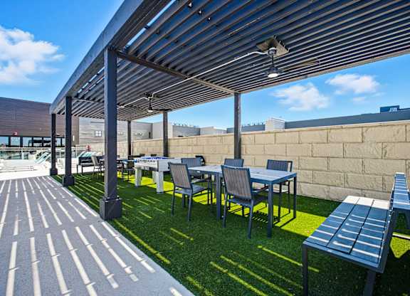 A patio with tables and chairs under a roof.