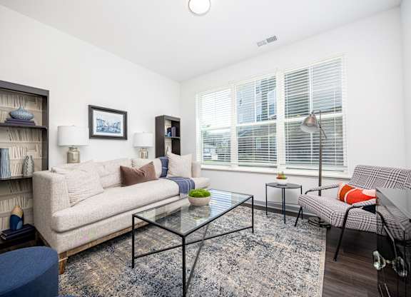 A living room with a couch, a chair, a coffee table, and a bookshelf.